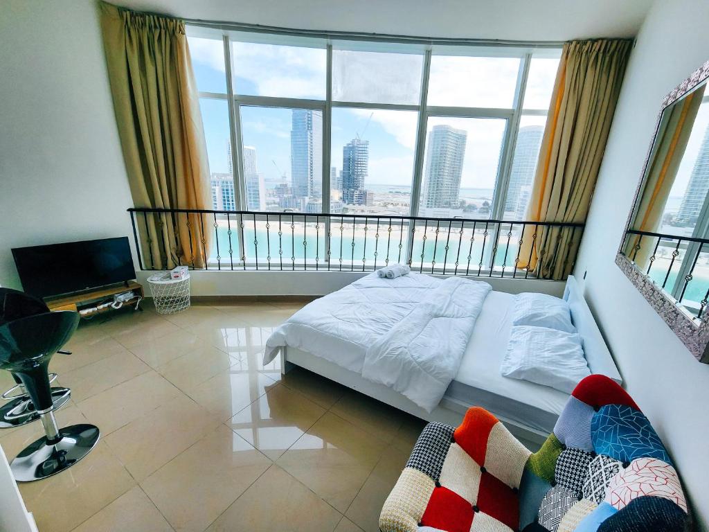 a bedroom with a bed and a large window at Comfy Studio with Stunning Vista, Pool and Gym in Abu Dhabi