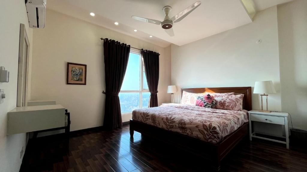 a bedroom with a bed and a large window at Luxury 1-Bed Apt Ideal for Couples in Islamabad