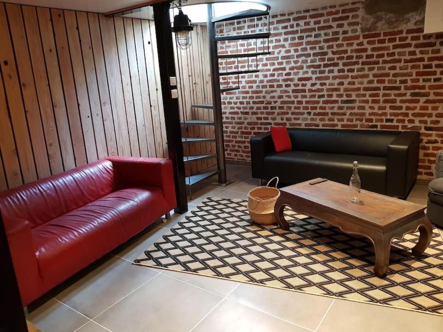 een woonkamer met een bank en een salontafel bij la Brise Malouine+jardin in Duinkerke