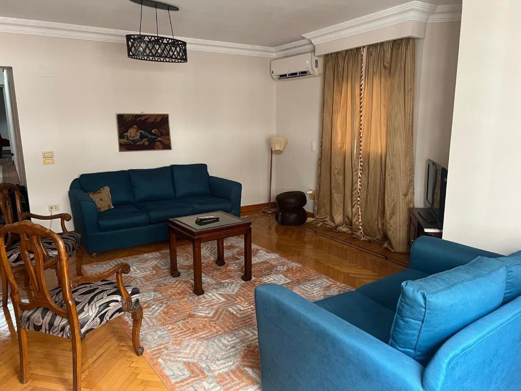 Maadi Serenity:3BR Inviting Home في القاهرة: غرفة معيشة مع أريكة زرقاء وطاولة
