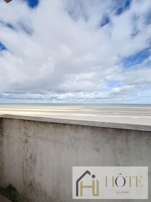 a sign on the side of a wall near the ocean at Résidence Saint Pierre: Vue Mer, 2 Chambres in Bray-Dunes