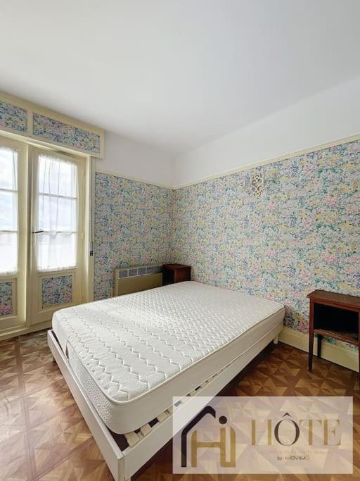 a bedroom with a bed in a room with wallpaper at Résidence Saint Pierre: Vue Mer, 2 Chambres in Bray-Dunes