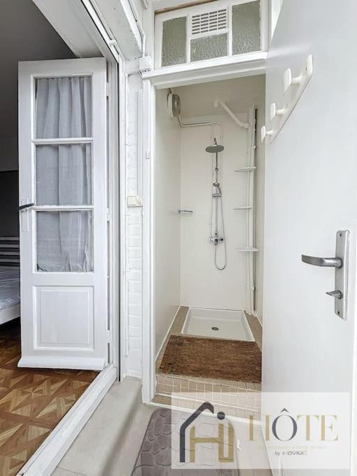 a bathroom with a shower with a white door at Résidence Saint Pierre: Vue Mer, 2 Chambres in Bray-Dunes