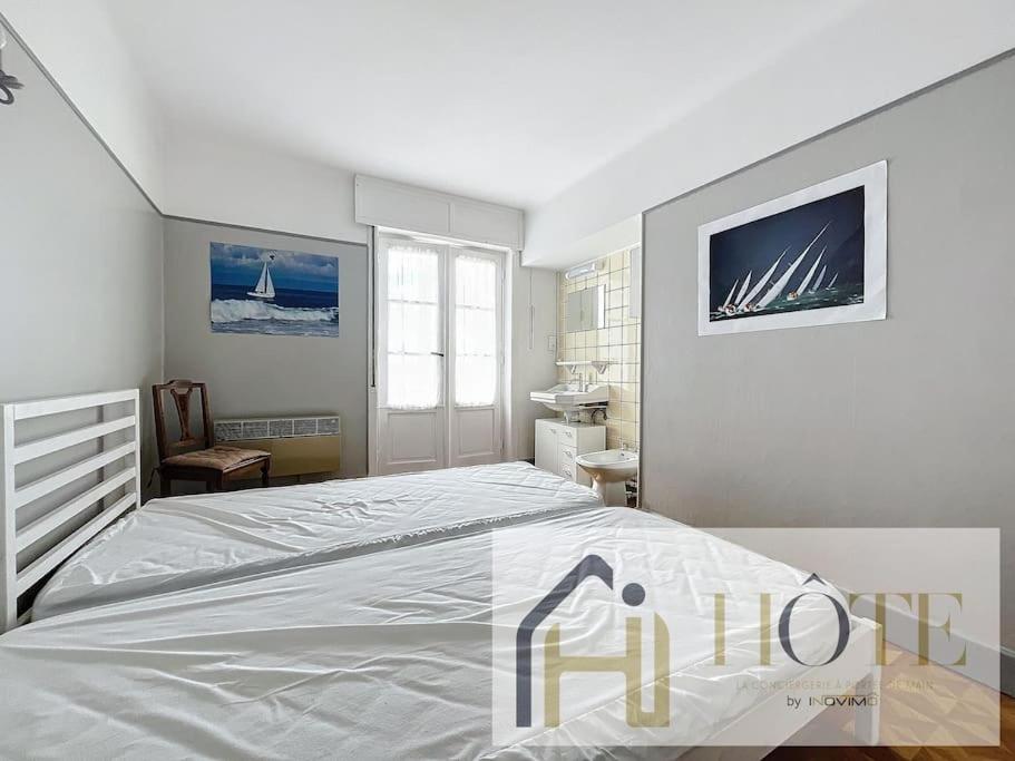 a white bedroom with a bed and a desk at Résidence Saint Pierre: Vue Mer, 2 Chambres in Bray-Dunes