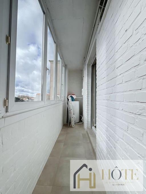 a hallway with windows and a white wall at Résidence Saint Pierre: Vue Mer, 2 Chambres in Bray-Dunes
