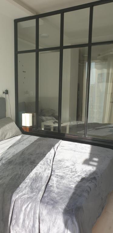uma cama num quarto com uma grande janela em Studio In sky el Gandoul compound em Hurghada
