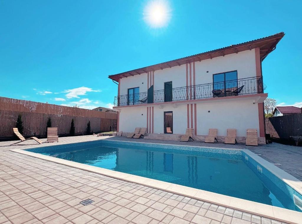 a villa with a swimming pool in front of a house at B'LEK SEA RESORT in 2 Mai
