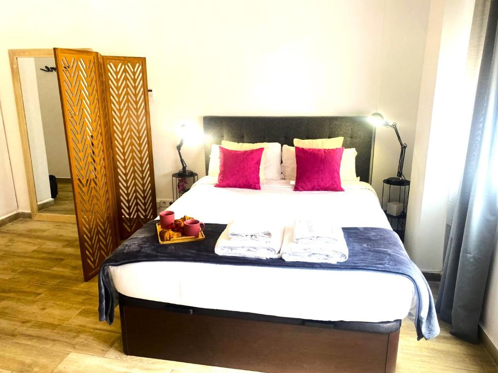 - une chambre avec un grand lit et des oreillers rouges dans l'établissement Precioso estudio en centro historico de Malaga, à Malaga