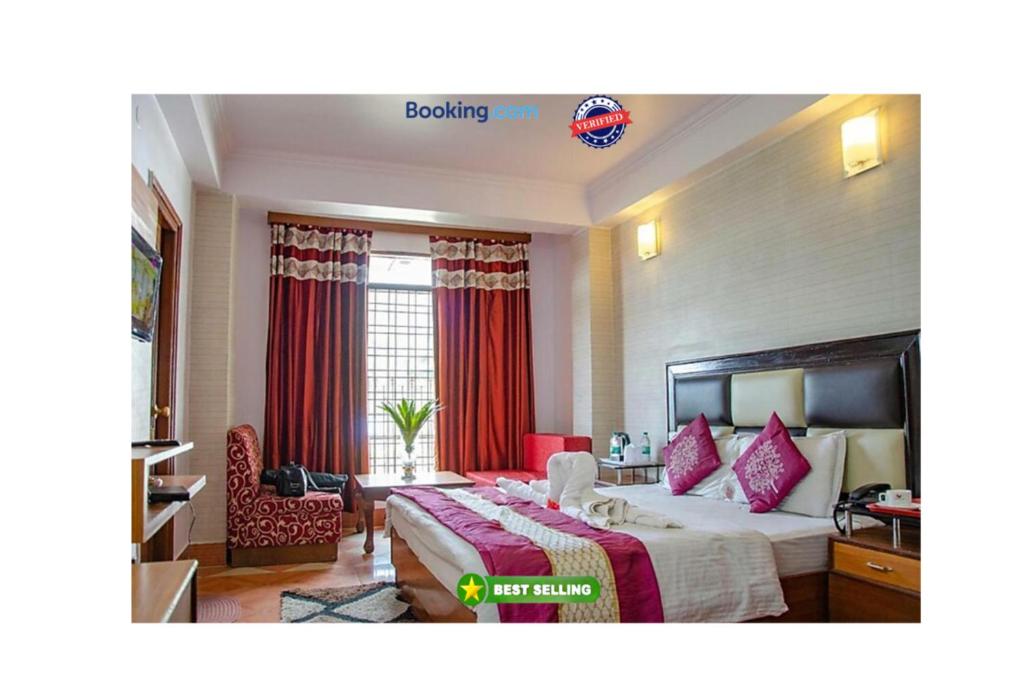 um quarto de hotel com uma cama com cortinas vermelhas em Hotel Abhinandan Mussoorie Near Mall Road - Parking Facilities & Prime Location - Best Hotel in Mussoorie em Mussoorie