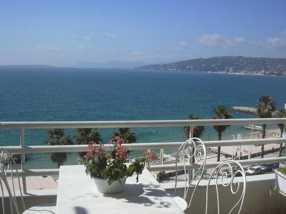 balcón con mesa, sillas y vistas al océano en Ma terrasse sur le front de mer et vue panoramique. Antibes - Juan-les-pins, en Antibes