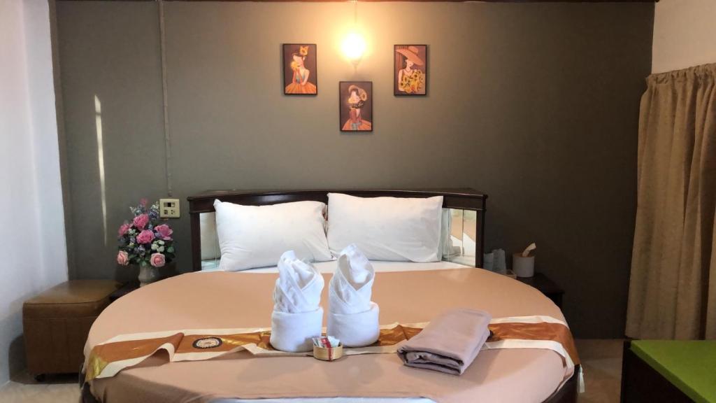 ein Schlafzimmer mit einem Bett mit zwei Schuhpaaren in der Unterkunft ทุ่งทองรีสอร์ท in Ban Khlong Toei (1)