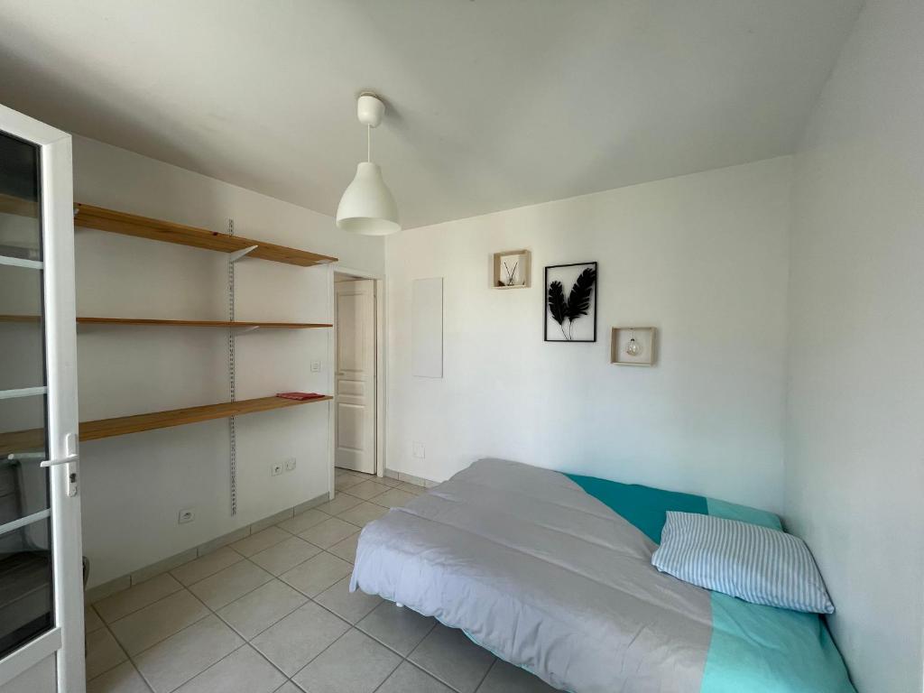 a bedroom with a bed and a book shelf at La maison de la plage in Saint-Georges-dʼOléron