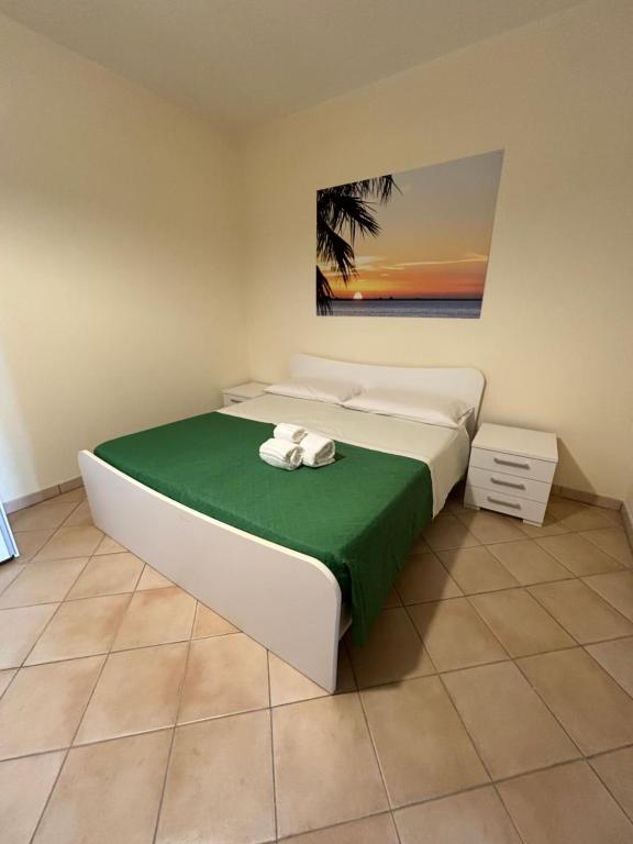 1 dormitorio con 1 cama grande con manta verde en Oasi Kite - Stagnone Apartments en Birgi Vecchi