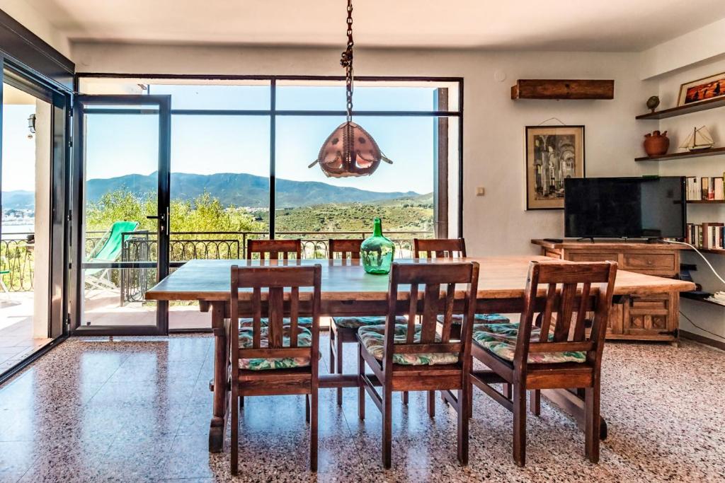 a dining room with a table and chairs and a large window at Grifeu 07 - Apartamento con vistas al mar in Girona