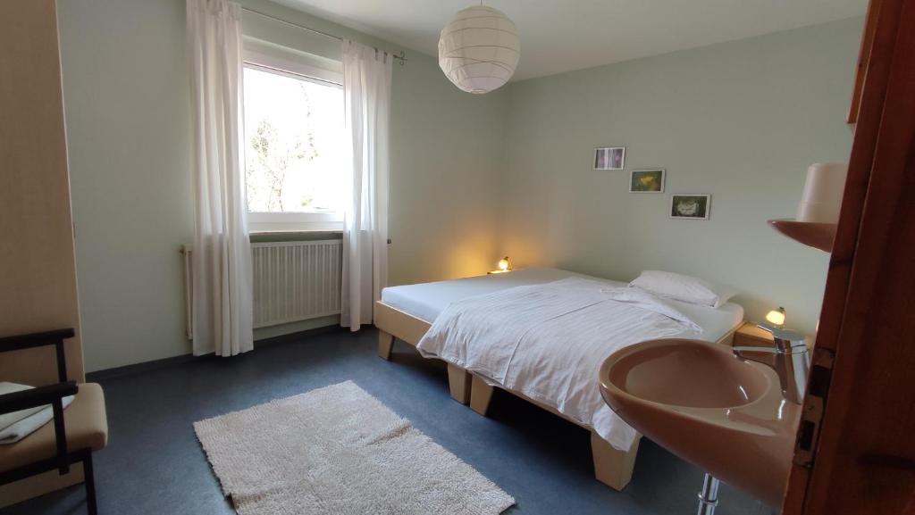 a bedroom with a bed and a sink and a window at Ferienwohnung Familie Haas in Gößweinstein