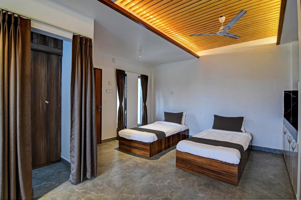 a bedroom with two beds and a ceiling at OYO Flagship Welcome Premium in Khandagiri