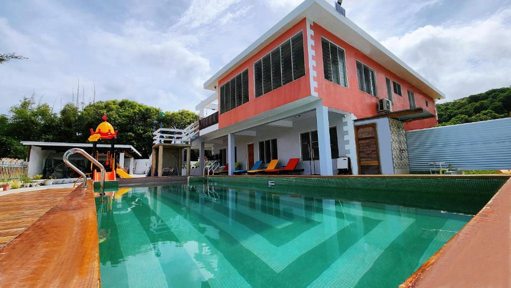 a house with a swimming pool in front of a house at Pacific Paradise Villa in Sigatoka