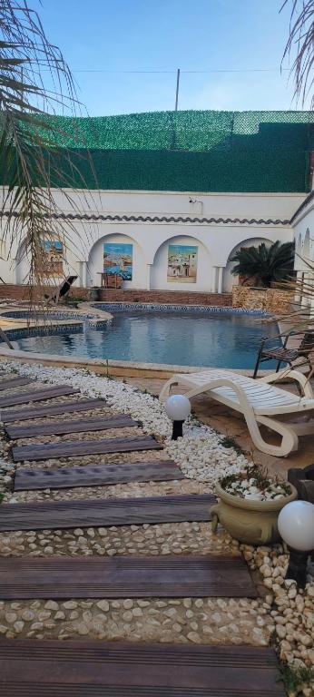 a swimming pool in a building with wooden steps at TRAPOLLA in El Djamila