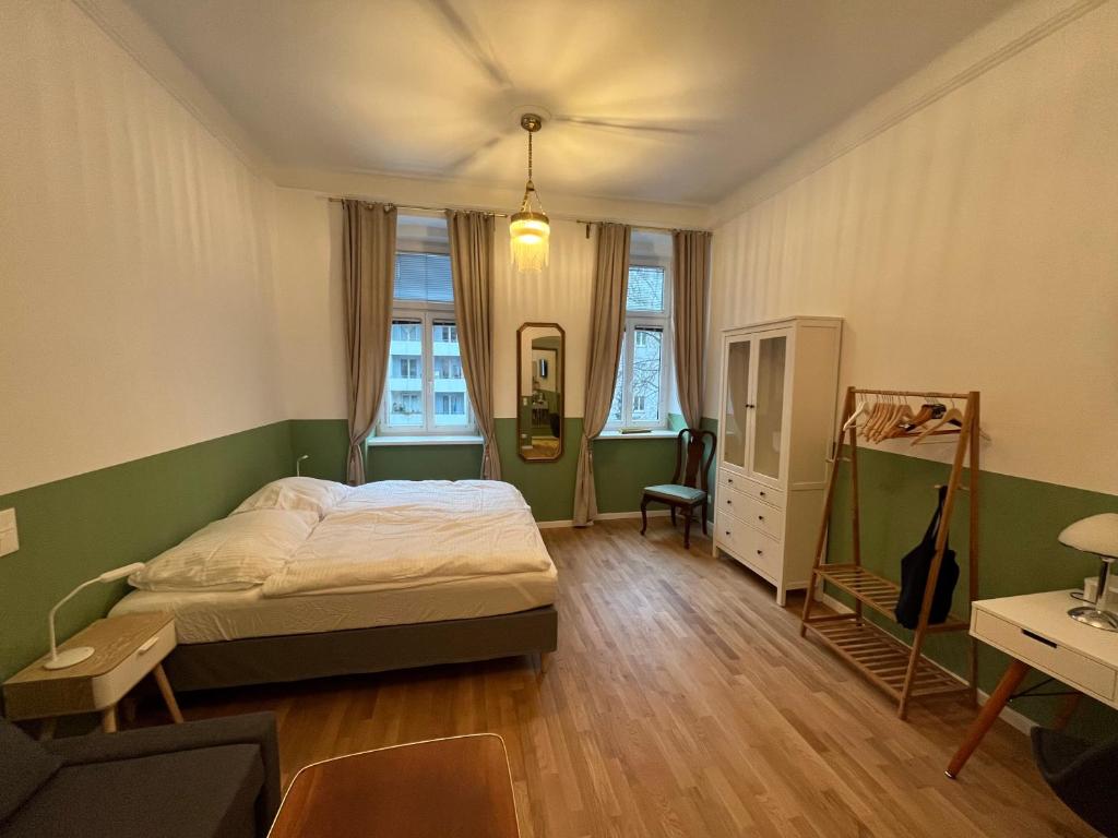 um quarto com uma cama, uma secretária e janelas em Urban Citytrip Flat - 15 min to Center em Viena