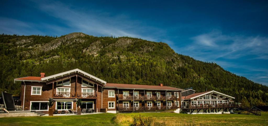 a large building with a mountain in the background at Eriksgårdens Fjällhotell in Funäsdalen
