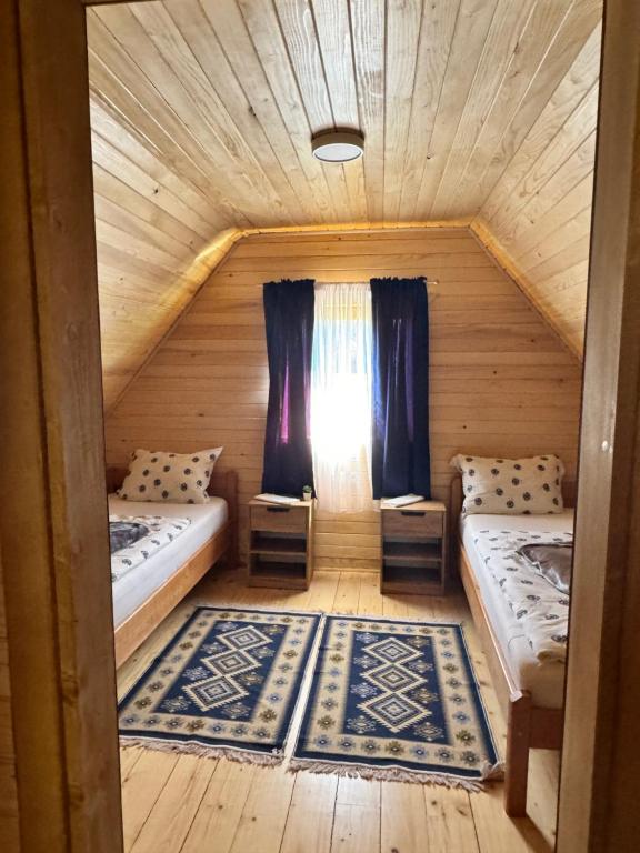 Cette petite chambre comprend 2 lits et une fenêtre. dans l'établissement Bungalow Fly Fishing Kljuc River Sanica, à Zolaći