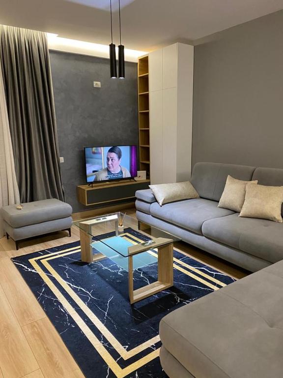 a living room with a couch and a tv at DiMarla Apartment in Tirana