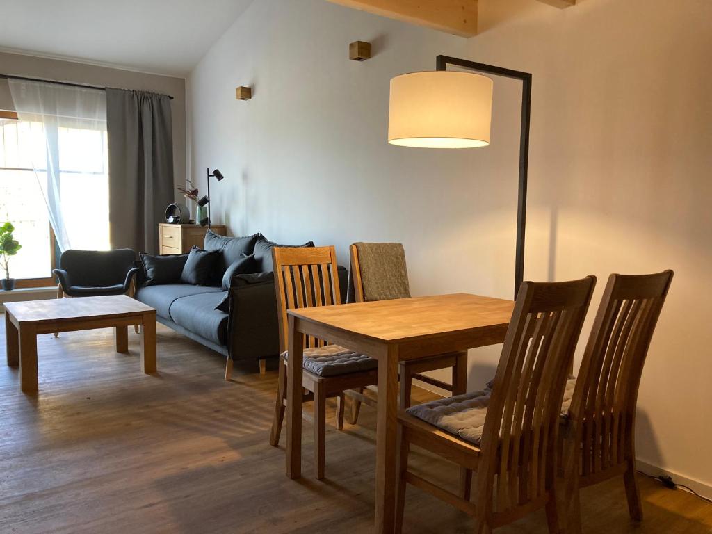 a living room with a table and chairs and a couch at Ferienwohnung Pferdehof Birkholz 