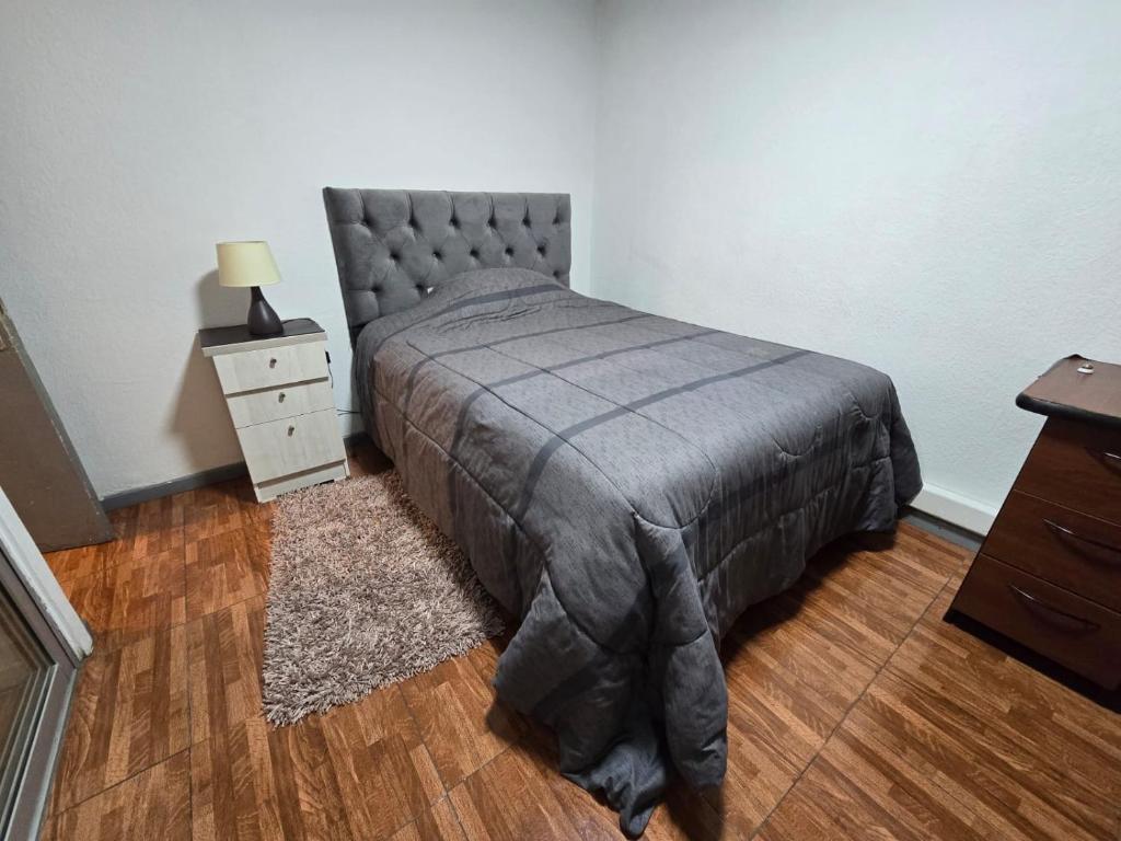 um quarto com uma cama e uma mesa-de-cabeceira e uma cama sidx sidx em Habitacion Privada Central cercana a Terminal Ohiggins em Rancagua