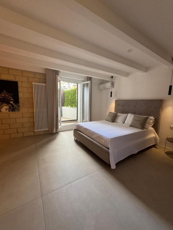 a bedroom with a large bed and a large window at SantaTeresa19 Suite & Spa in Palermo