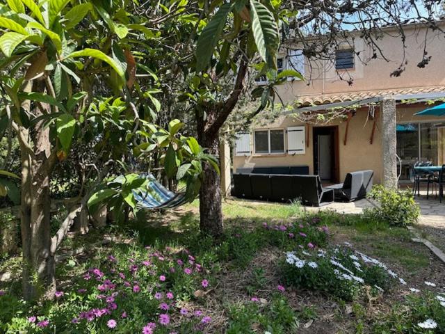 Casa con jardín con sofá y flores en Villa familiale carlex, en Sète