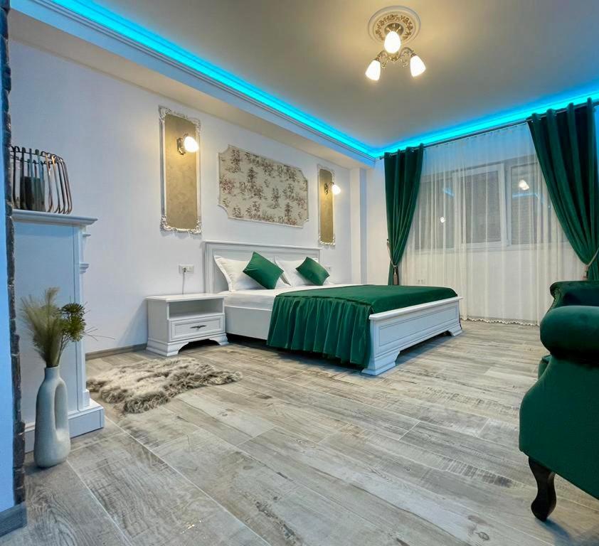 a bedroom with a bed with green pillows in it at Apartament Modern in Craiova