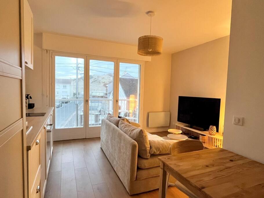uma sala de estar com um sofá e uma mesa em Appartement avec Balcon et place de Parking à Berck Plage em Berck