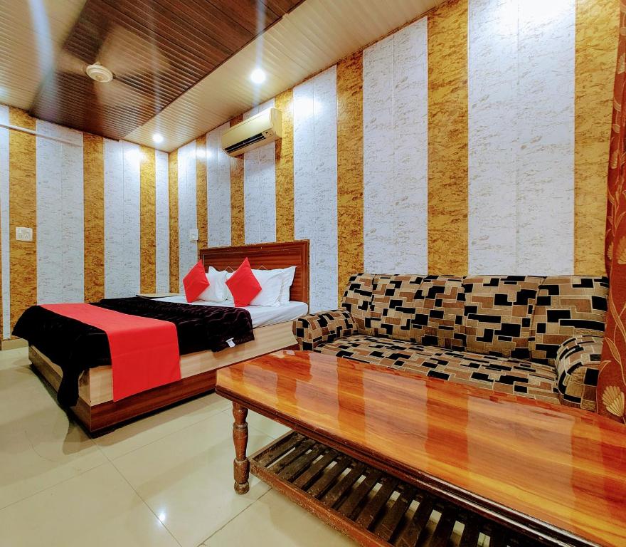 Hotel Grand في Zirakpur: غرفة بسريرين واريكة فيها