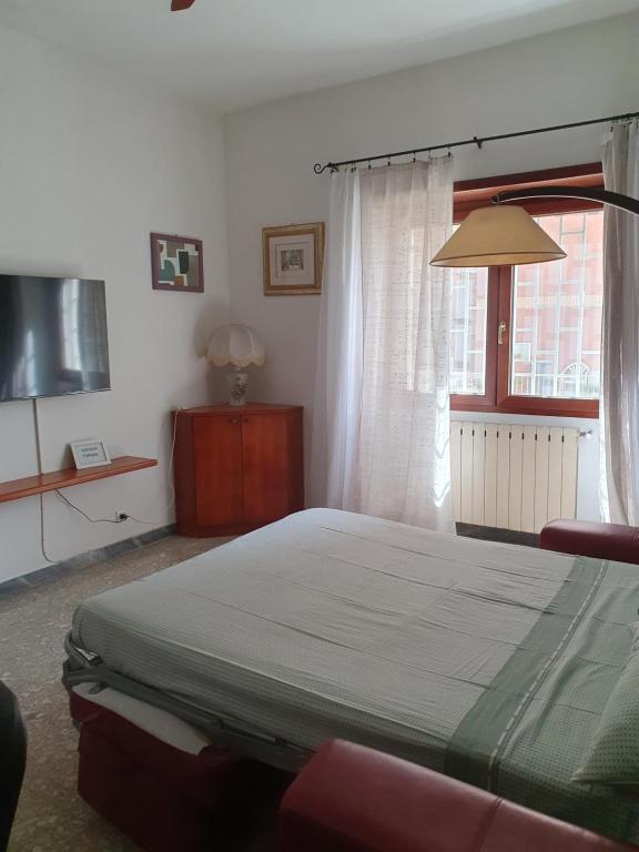 sypialnia z łóżkiem i oknem w obiekcie Casa Diana Ostia w mieście Lido di Ostia