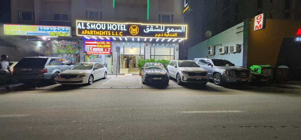 Al Smou Hotel Apartments - MAHA HOSPITALITY GROUP في عجمان: مجموعة من السيارات تقف في موقف للسيارات