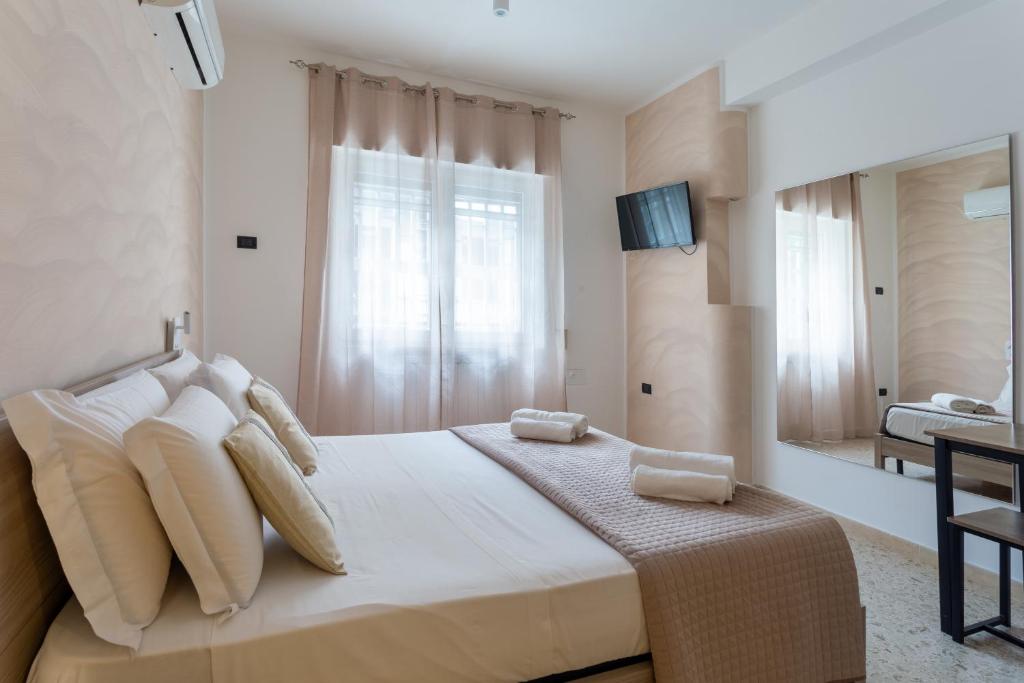 a bedroom with a large white bed with white pillows at Napoli Fly Guest House 290 in Naples