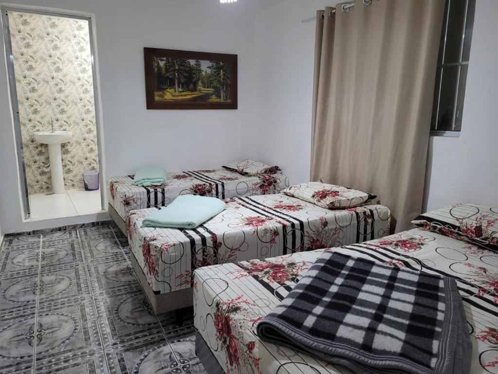 Zimmer mit 3 Betten und einem Fenster in der Unterkunft Cantinho da Irene III in Aparecida