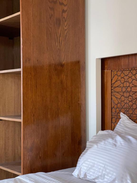 a bedroom with a wooden headboard and a bed at Queen cleopatra sphinx view in Cairo