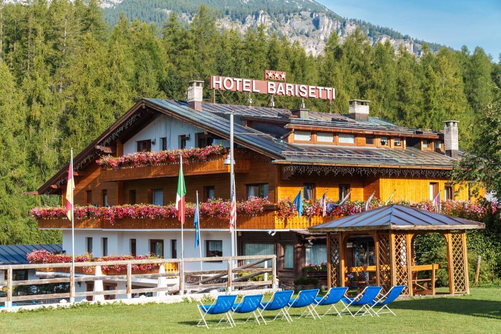 un hotel con sillas frente a un edificio en Barisetti Sport Hotel en Cortina dʼAmpezzo