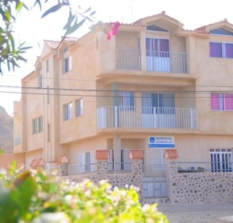 un gran edificio con balcones en un lateral en Residencial Sao Miguel, en Calheta