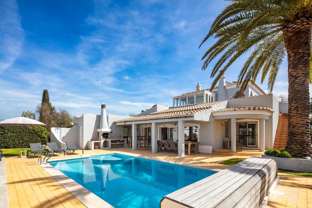 una casa con una piscina y una palmera en Villa at walking distance from center and beach!, en Carvoeiro