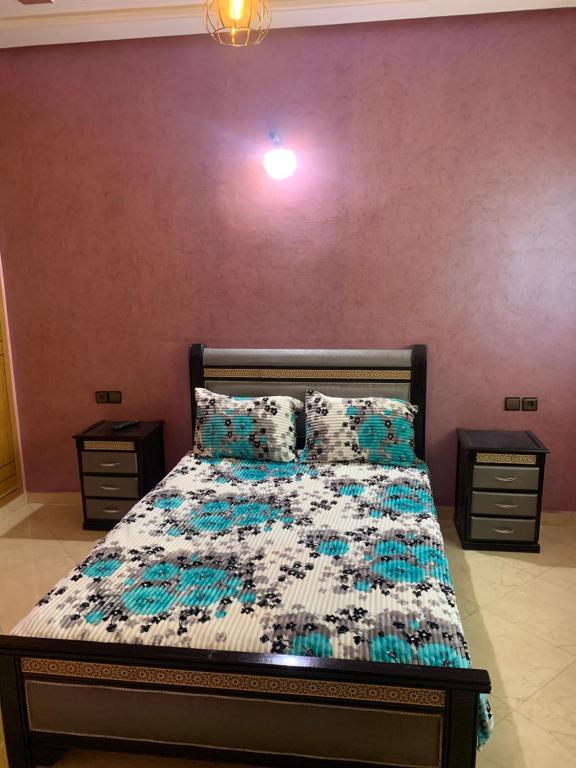 1 cama en un dormitorio con 2 mesitas de noche y 2 mesas en Appartement a loué fes, en Fez