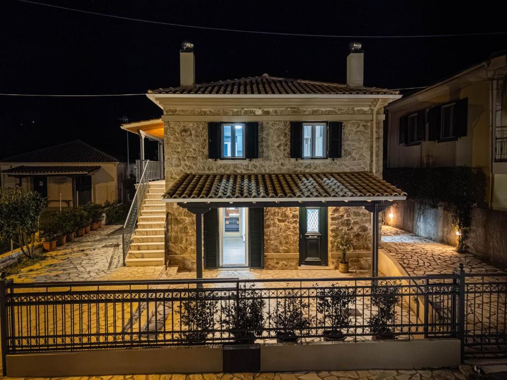 una casa de piedra por la noche con una puerta en Spyros Stone Apartment en Lazaráta