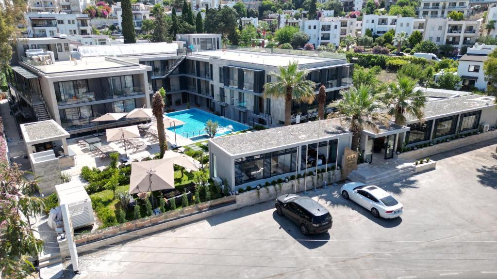 an aerial view of a building with a car parked in a parking lot at Bitez Adam Otel in Bodrum City
