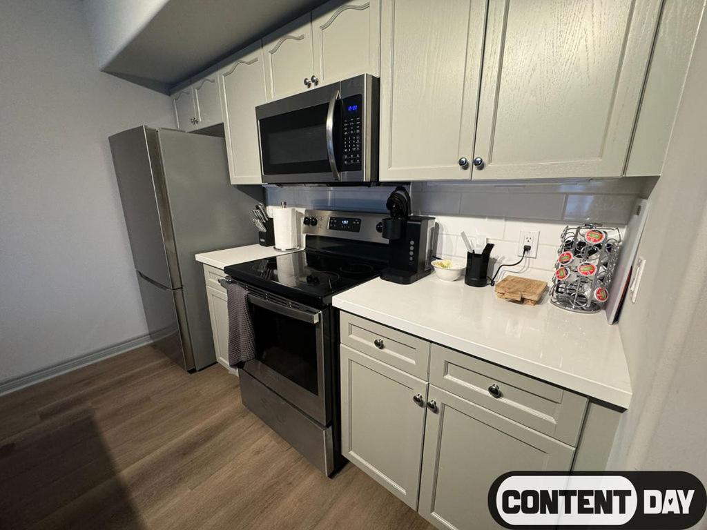 a kitchen with a stove and a microwave at Valley Vista Haven - Exquisite Condo Retreat with Jacuzzi - Top Floor Romance - Self-Check-in - Gourmet Kitchen - Heated Pool Paradise in Shanty Bay