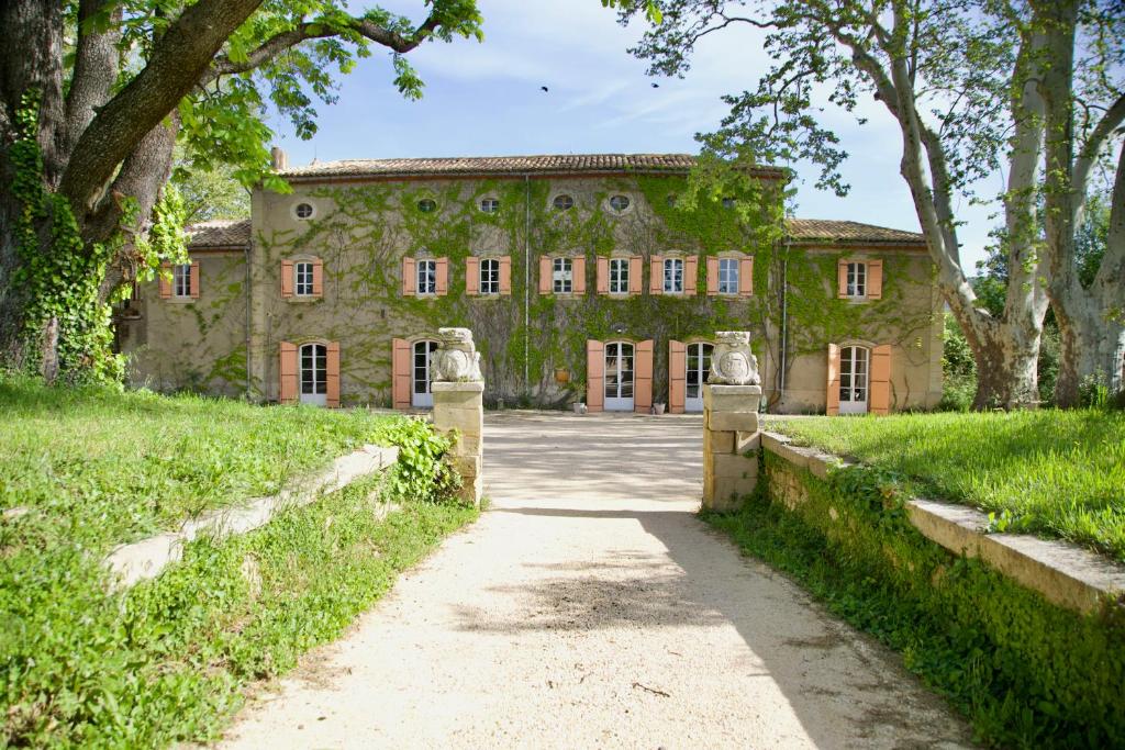 ein altes Steinhaus mit einem Weg davor in der Unterkunft Château de Sienne proche Avignon Orange 7 Chambres Piscine Rivière in Chusclan