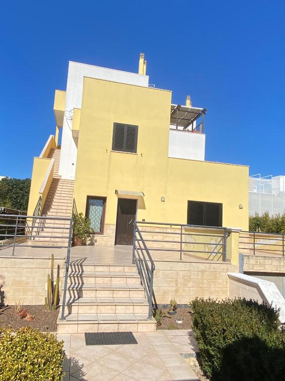 a yellow building with stairs in front of it at Le tre terrazze - Gallipoli in Gallipoli