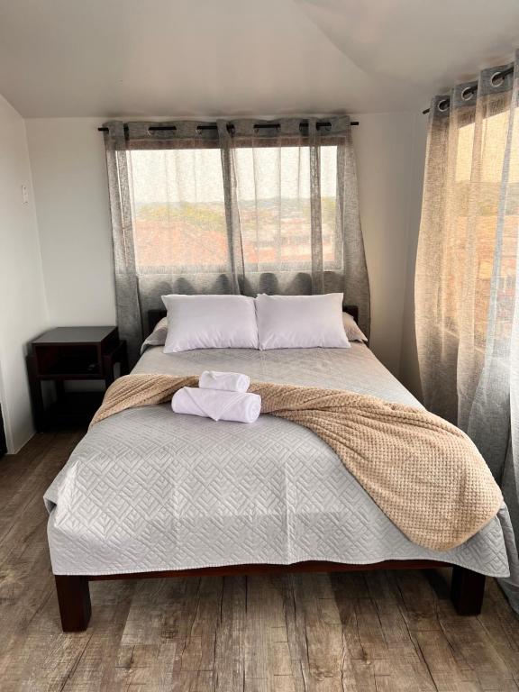 - une chambre avec un lit et 2 serviettes dans l'établissement Studio Chic Skyview, à Puyo