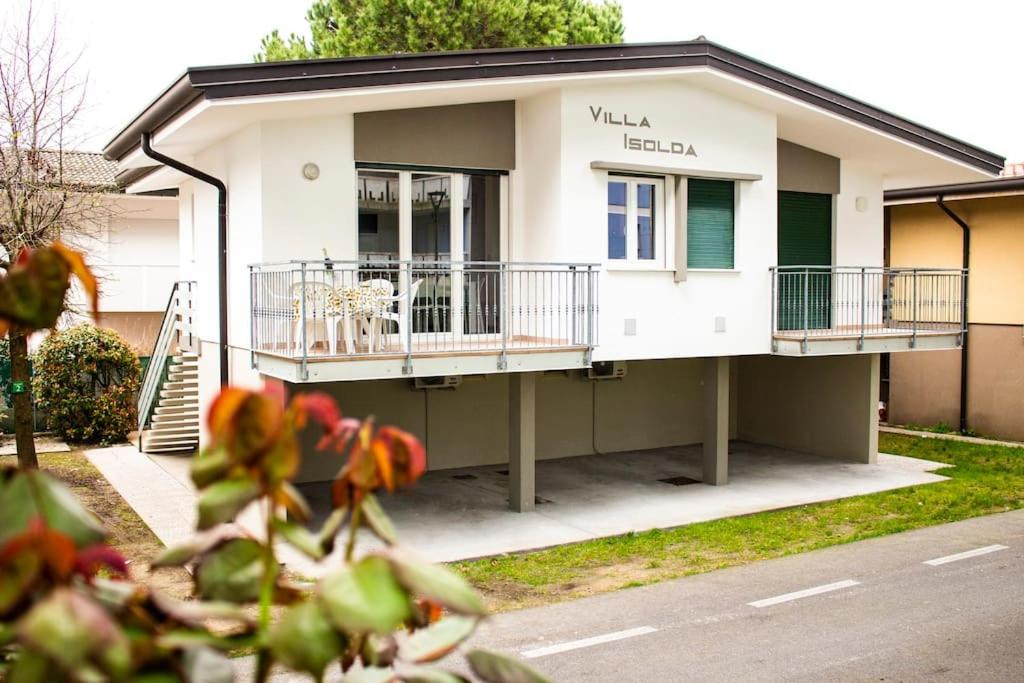 una pequeña casa blanca con balcones en una calle en Villa Isolda: moderno trilocale, en Bibione