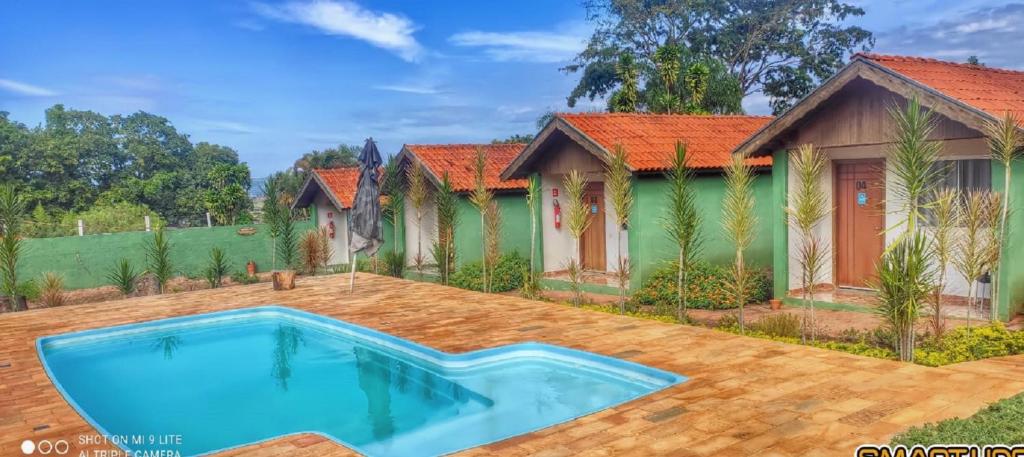 Villa con piscina frente a una casa en Pousada Recanto das Maritacas, en Brotas